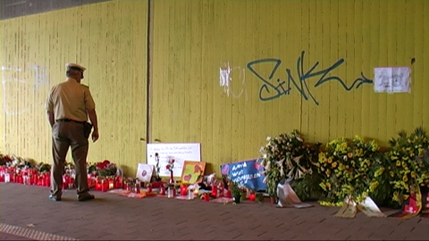 loveparade_polizist_vor_kraenzen